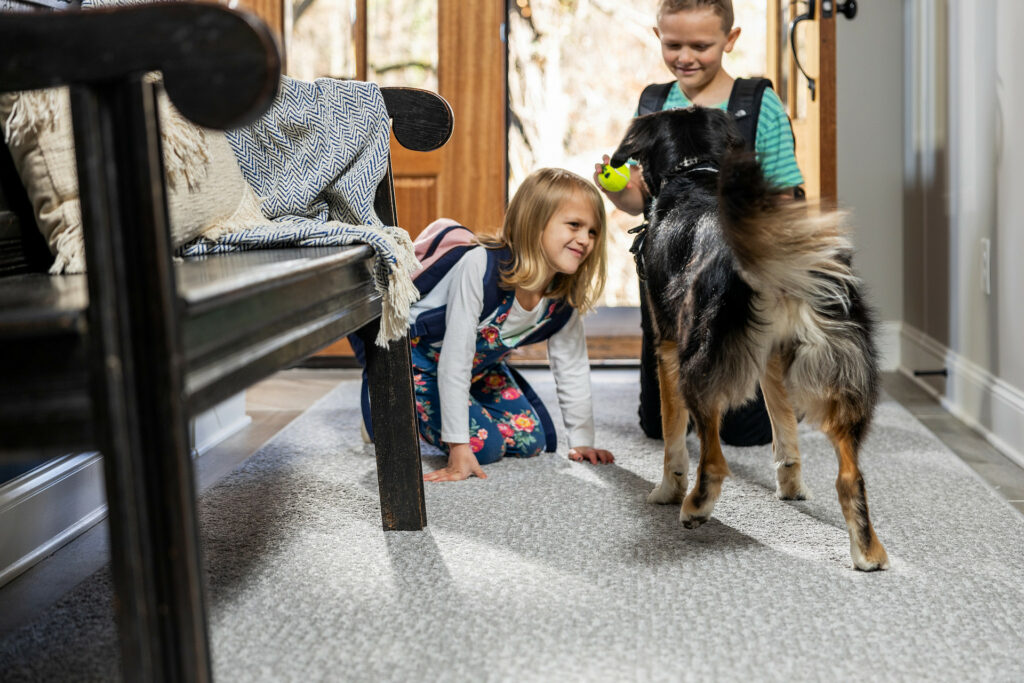Kids playing with dog on carpet floors | Flemington Department Store